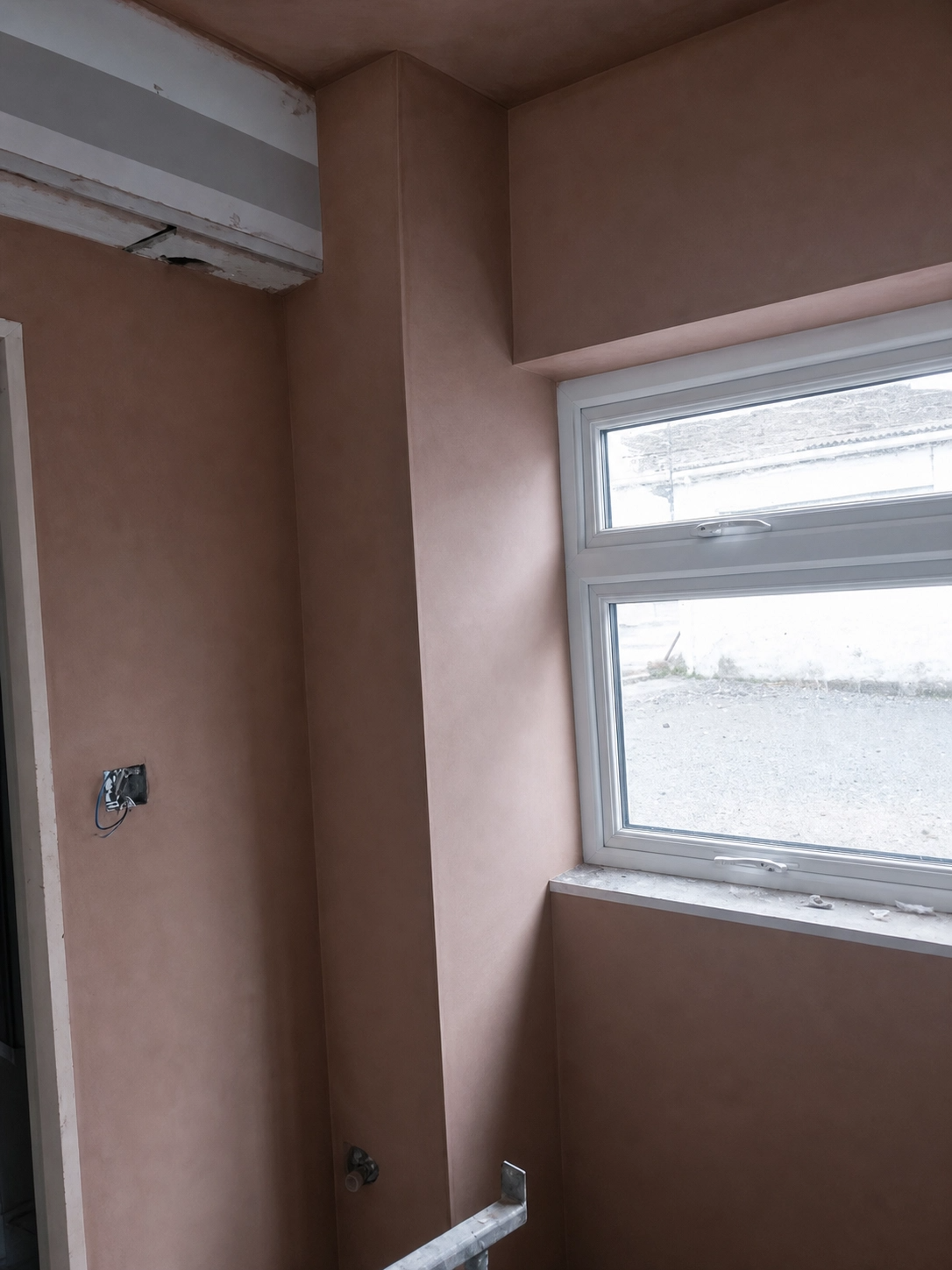 Freshly skimmed pink plaster walls